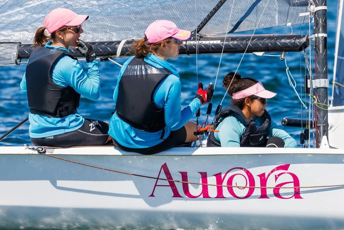 A racing sailboat crew working together on the water